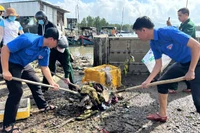 Đoàn viên thanh niên giúp người dân dọn bùn đất sau bão.