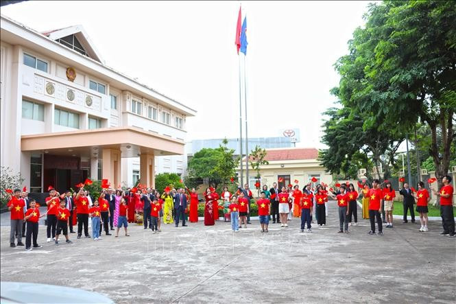 Cán bộ, nhân viên Đại sứ quán Việt Nam tại Lào giơ cao lá cờ đỏ sao vàng hướng về Tổ quốc. (Ảnh: Xuân Tú/PV TTXVN tại Lào) Cán bộ, nhân viên Đại sứ quán Việt Nam tại Lào giơ cao lá cờ đỏ sao vàng hướng về Tổ quốc. (Ảnh: Xuân Tú/PV TTXVN tại Lào)