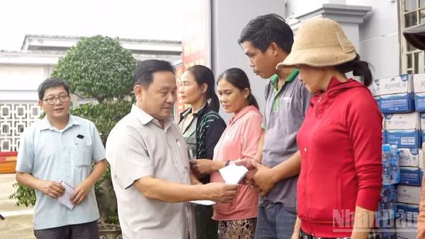 Phó Chủ tịch Hội đồng nhân dân thành phố Đà Nẵng Nguyễn Công Thanh tặng quà cho các hộ dân ở xã Quế Phước bị thiệt hại nặng do mưa lũ gây ra.