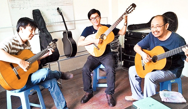 Trao đổi về sở thích chơi đàn ghi-ta cổ tại Trung tâm Nhạc cụ Sông Mơ (quận 10).
