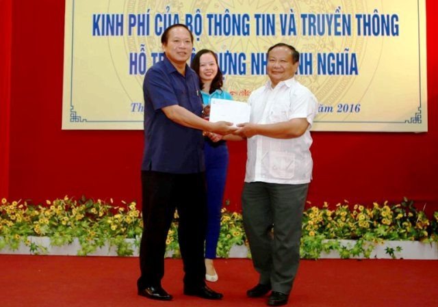 Bộ trưởng Trương Minh Tuấn trao số tiền 200 triệu đồng cho lãnh đạo tỉnh để hỗ trợ xây nhà tình nghĩa cho các gia đình chính sách.