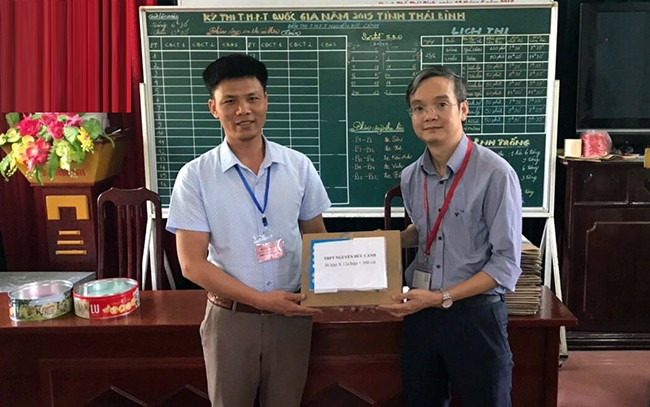 Đại diện Trường đại học Ngoại thương trao bút chì hỗ trợ thí sinh làm bài thi trắc nghiệm tại tỉnh Thái Bình.Ảnh: PHƯƠNG HÀ