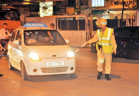 Một taxi bị CSGT yêu cầu dừng lại để xử lý vi phạm. Ảnh: MẠNH TRƯỜNG