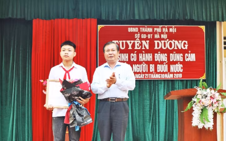 Em Phan Trung Hiếu nhận bằng khen của UBND thành phố về hành động dũng cảm cứu người bị nạn.