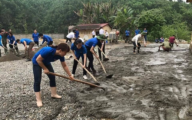 Cán bộ Tỉnh đoàn giúp Trường tiểu học xã Quảng Chu, huyện Chợ Mới (Bắc Cạn) đổ bê-tông sân trường.