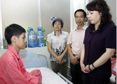 Bộ trưởng Bộ Y tế Nguyễn Thị Kim Tiến thăm bệnh nhân Nguyễn Viết Khuê. (Ảnh: baodatviet.vn)