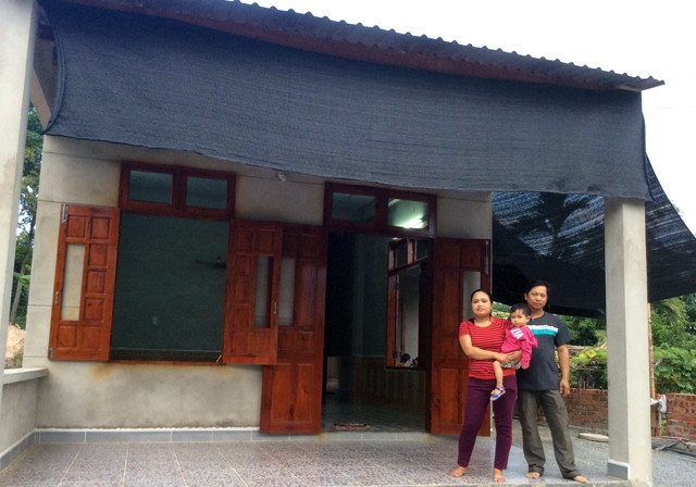 Vợ chồng công nhân Sa Thị Tới trước căn nhà chống bão vừa khánh thành.