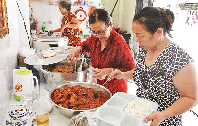 Bà Nguyễn Thị Phương (người thứ hai từ phải sang) cùng các cộng sự chuẩn bị bữa ăn cho người nghèo.