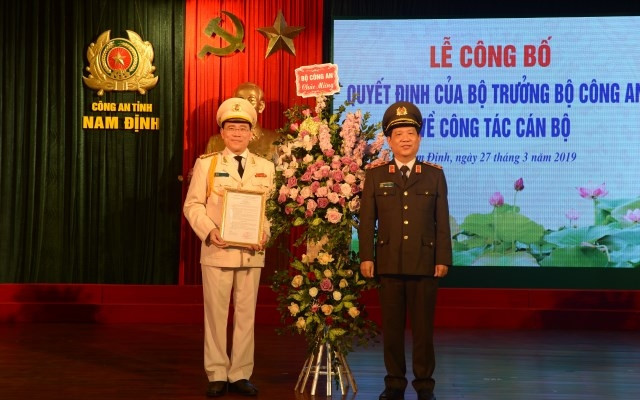 Trung tướng Nguyễn Văn Sơn, Thứ trưởng Công an trao quyết định bổ nhiệm Giám đốc Công an tỉnh Nam Định và tặng hoa chúc mừng Đại tá Phạm Văn Long.