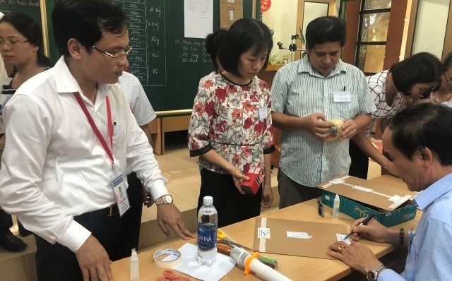 Cán bộ coi thi làm quy trình niêm phong túi đựng bài thi theo quy định của quy chế tại điểm thi THPT Nguyễn Huệ (Tam Điệp, Ninh Bình).