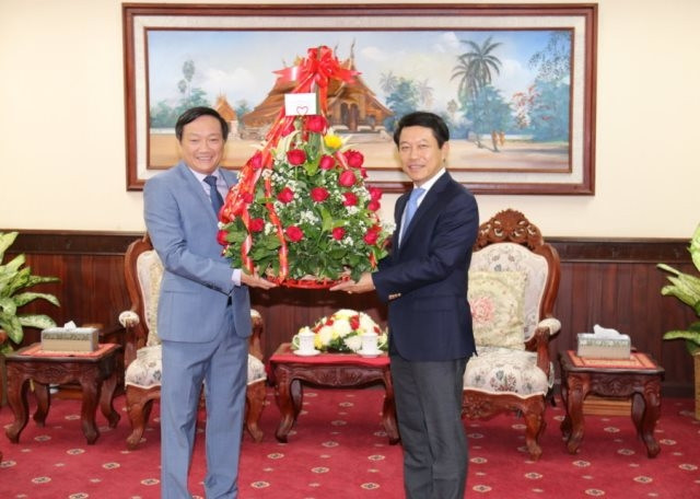 Đại sứ Việt Nam tại Lào Nguyễn Bá Hùng (trái) trao lẵng hoa chúc mừng Bộ trưởng Ngoại giao Lào Saleumxay Kommasith nhân dịp Tết cổ truyền 2019 của Lào