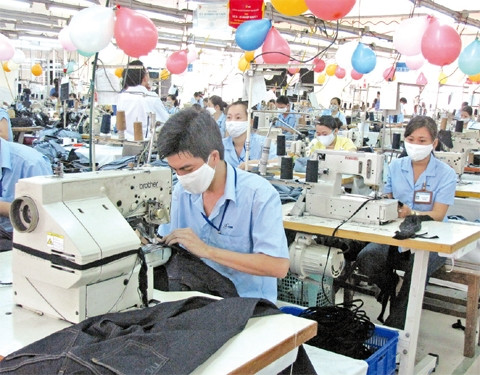 Công nhân may gia công quần âu xuất khẩu tại một công ty may mặc ở thành phố.