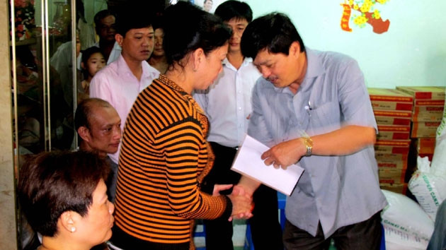 Phó Chủ tịch UBND Hồ Việt Hiệp (bên phải) trao tiền hỗ trợ bà con bị thiệt hại do cháy.