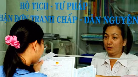 Cán bộ hộ tịch P.10, Q.Phú Nhuận trả kết quả đăng ký khai sinh, nhập khẩu và làm thủ tục cấp thẻ bảo hiểm y tế cho người dân. (Ảnh: thanhnien.com.vn)