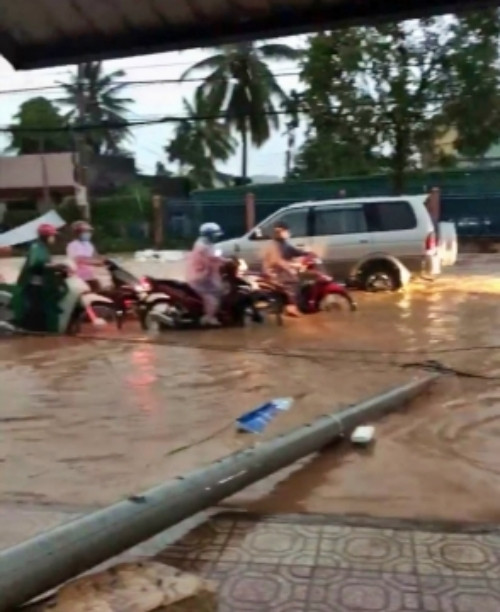 Một tuyến đường ở thị trấn Lạc Tánh, huyện Tánh Linh, tỉnh Bình Thuận bị ngập sâu, trụ điện bị ngã đổ do mưa lớn, lốc xoáy.