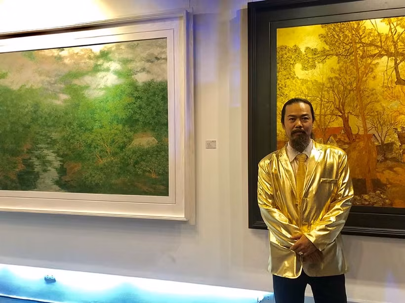 Họa sĩ Nguyễn Quốc Huy bên các tác phẩm tại Triển lãm.