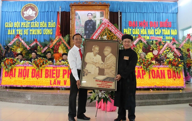 Lãnh đạo Huyện ủy Phú Tân tặng tranh cho Đại diện Ban trị sự Trung ương Giáo hội Phật giáo Hòa Hảo.