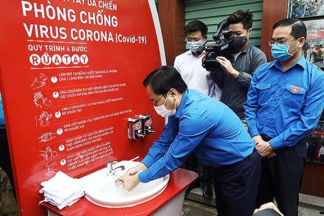 Bí thư Thường trực T.Ư Đoàn TNCS Hồ Chí Minh Nguyễn Anh Tuấn rửa tay tại công trình đầu tiên trong số 100 trạm rửa tay dã chiến.