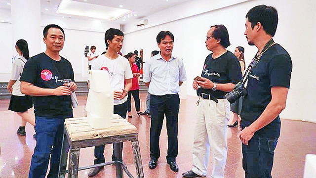 Các nghệ sĩ trao đổi tại triển lãm.