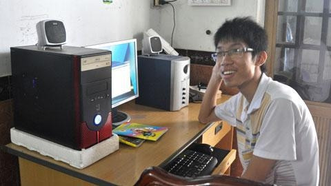 Tân thủ khoa Trần Nhật Hoàng bên bộ vi tính cũ người anh họ vừa tặng.