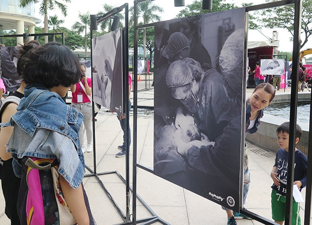 Các bạn trẻ tham quan những bộ ảnh tại triển lãm.