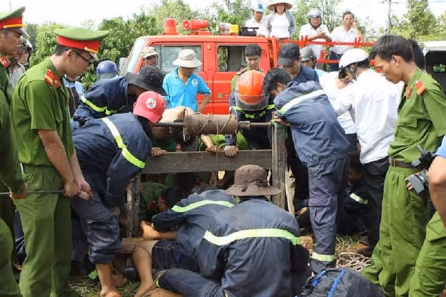 Lực lượng cứu hộ nỗ lực đưa thi thể các nạn nhân lên khỏi miệng giếng.
