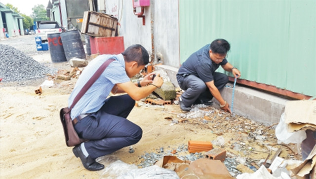 Nhân viên Văn phòng Thừa phát lại quận Thủ Đức làm các thủ tục để lập vi bằng về hiện trạng xây dựng nhà của một hộ dân trên địa bàn.