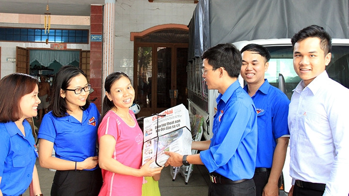 Tặng báo cho công nhân, lao động ở một khu nhà trọ tại huyện Vĩnh Cửu, tỉnh Ðồng Nai.