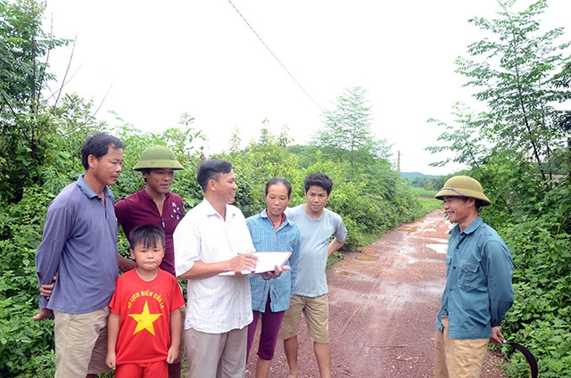 Ðồng chí Trần Minh Ðăng, Bí thư Chi bộ đồng thời là Trưởng bản Cầu Ðá, xã Thượng An (Yên Thế, Bắc Giang) gặp gỡ người dân, tuyên truyền về chủ trương cứng hóa đường giao thông thôn, bản. Ảnh: Quốc Trư