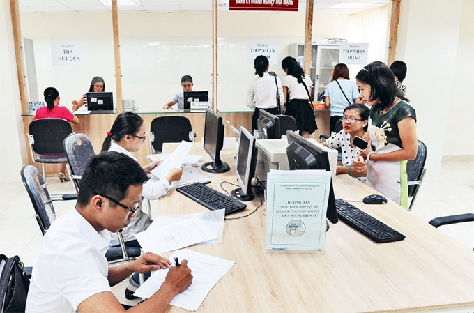 Doanh nghiệp đến làm thủ tục hành chính tại Bộ phận đăng ký doanh nghiệp qua mạng (Sở Kế hoạch và Ðầu tư). Ảnh: DUY LINH