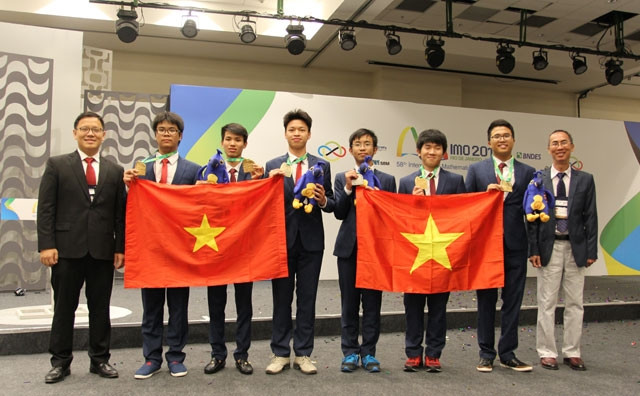 PGS,TS Lê Anh Vinh (Trưởng đoàn); TS Lê Bá Khánh Trình (Phó đoàn) cùng sáu học sinh trong lễ nhận giải Olympic Toán học quốc tế 2017 tại Brazil . Ảnh: GIANG SƠN