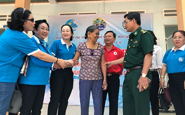 Ðại tá Tô Danh Út và đồng chí Nguyễn Hoàng Ân trao quà cho bà con người dân tộc Gia Rai nghèo diện chính sách ở Gia Lai.