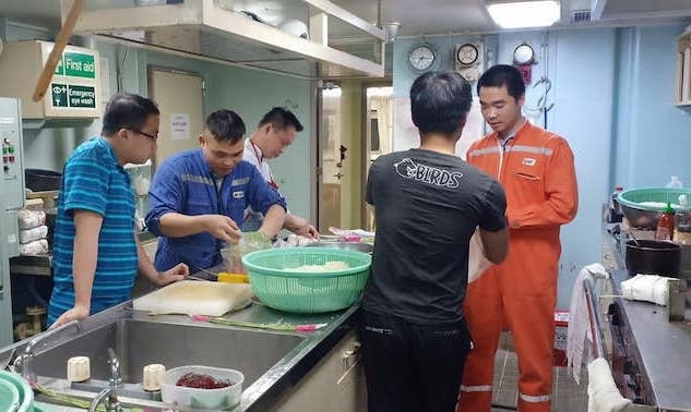 Các thuỷ thủ tàu M/v Glorius Poeny gói bánh chưng bằng vỏ bao gạo do không mua được lá gói.