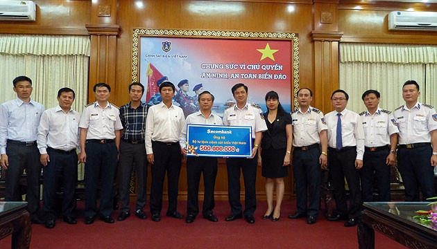 Đại diện Sacombank trao tiền ủng hộ cho đại diện BTL Cảnh sát biển Việt Nam.