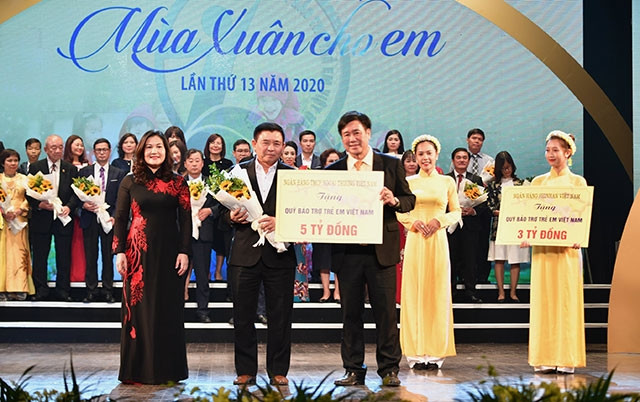 Ông Trần Phúc Cường – Phó Chủ tịch thường trực Công đoàn Vietcombank (đứng giữa) trao biển tượng trưng số tiền năm tỷ đồng cho đại diện Quỹ BTTE, với sự chứng kiến của Thứ trưởng LĐTB&XH Nguyễn Thị Hà