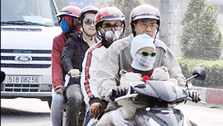 Người dân TP Hồ Chí Minh ra đường với quần áo rét, khăn len và bao tay.