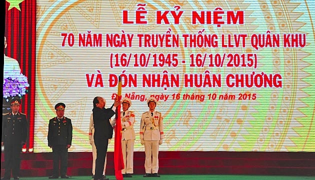 Thừa uỷ quyền Chủ tịch nước, đồng chí Nguyễn Xuân Phúc gắn Huân chương Quân công hạng nhất lên lá cờ Quyết thắng của Quân khu 5.