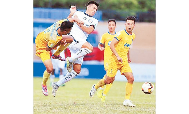 Pha tranh bóng giữa các cầu thủ FLC Thanh Hóa (áo vàng) và SHB Ðà Nẵng.