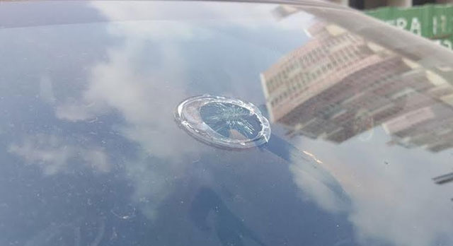 Kính ô-tô bị nứt do bị vật liệu xây dựng rơi vào.