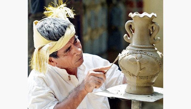 Nghệ nhân Đàng Xem ở làng gốm Bàu Trúc (Ninh Thuận) trong xưởng sản xuất. Ảnh: THANH HÀ