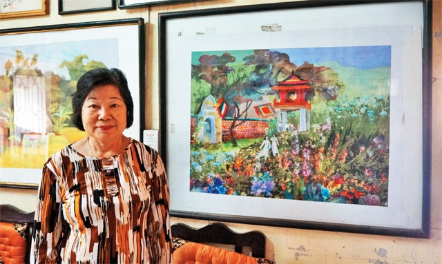 Họa sĩ Phương Lan bên bức tranh "Thăng Long  - Hà Nội nghìn năm" được ghép từ những mảnh vải vụn.