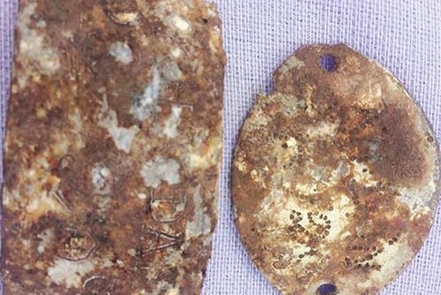 Nhiều tấm nhôm khắc tên và đơn vị nằm cùng hài cốt liệt sĩ.