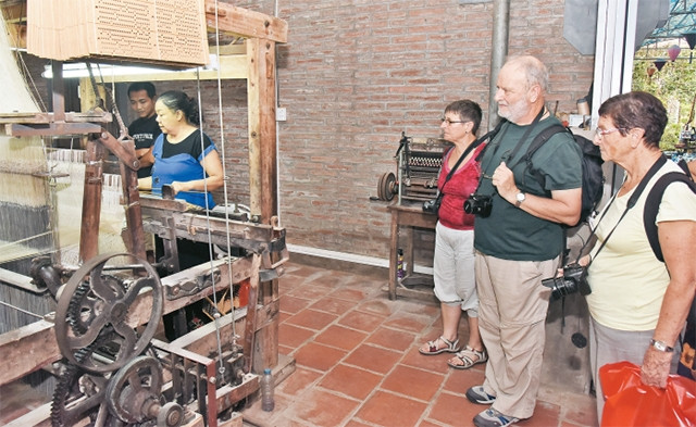 Du khách nước ngoài tham quan xưởng dệt lụa tại làng Vạn Phúc (Hà Đông).