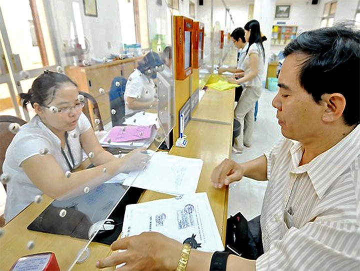 Cán bộ UBND quận 1, TP Hồ Chí Minh hướng dẫn người dân làm thủ tục hành chính. Ảnh: VIỆT DŨNG