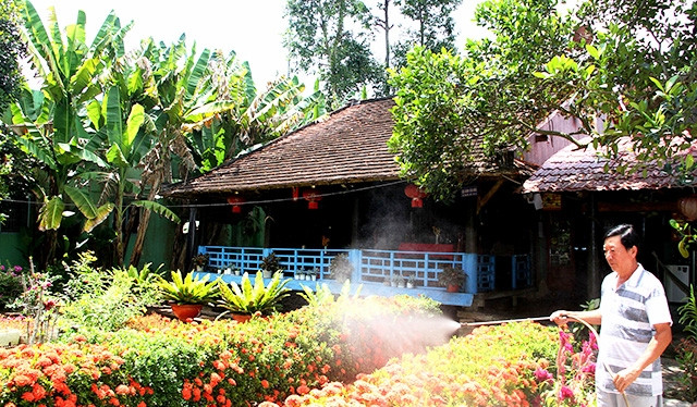 Ông Tôn Thất Đính chăm sóc hoa cảnh phục vụ du lịch cộng đồng bên ngôi nhà cổ hơn 140 năm tuổi của gia đình.