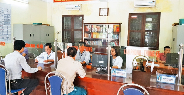 Cán bộ bộ phận một cửa huyện Phú Xuyên hướng dẫn người dân làm thủ tục hành chính.