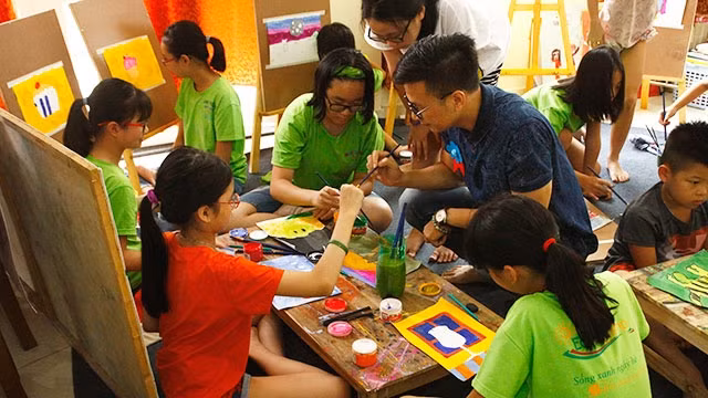 Họa sĩ Kim Duẩn hướng dẫn các em nhỏ vẽ tranh.