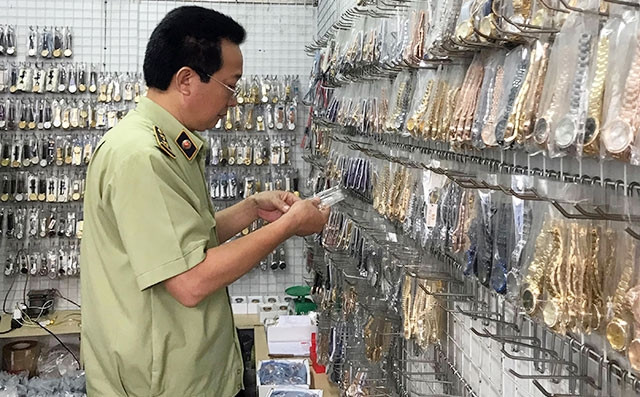 Cán bộ quản lý thị trường Hà Nội kiểm tra cơ sở kinh doanh tại chợ Ninh Hiệp, Gia Lâm. Ảnh: QUYÊN LƯU
