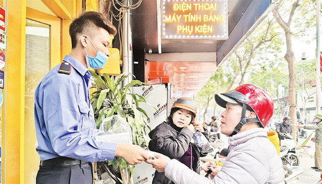Những ngày qua, trong khi có không ít hộ kinh doanh trục lợi bằng việc tăng giá mặt hàng khẩu trang y tế thì vẫn có một số cửa hàng phát miễn phí cho người dân. Trong ảnh: Người dân nhận khẩu trang ph