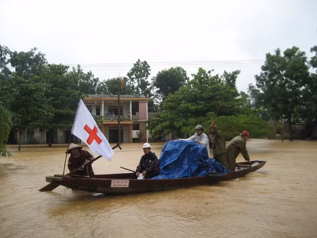 Các cán bộ Chữ thập đỏ tham gia cứu giúp bà con vùng lũ. Ảnh: TRUNG NGHĨA